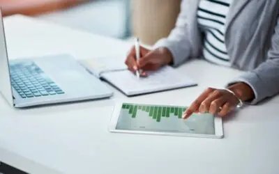 Shot of an unrecognizable businesswoman using a digital tablet with graphs on it in a modern office