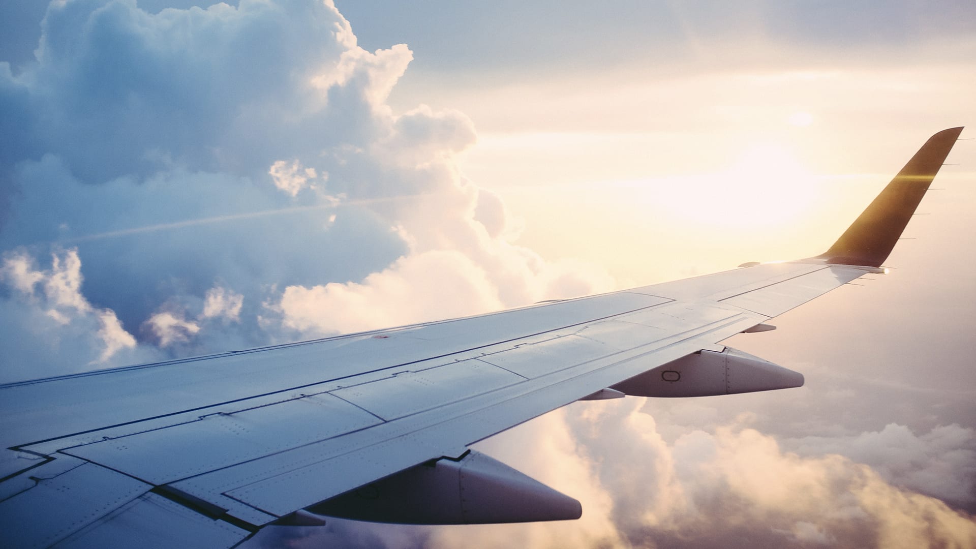 wing of a plane in flight in the clouds