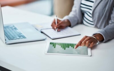 Shot of an unrecognizable businesswoman using a digital tablet with graphs on it in a modern office