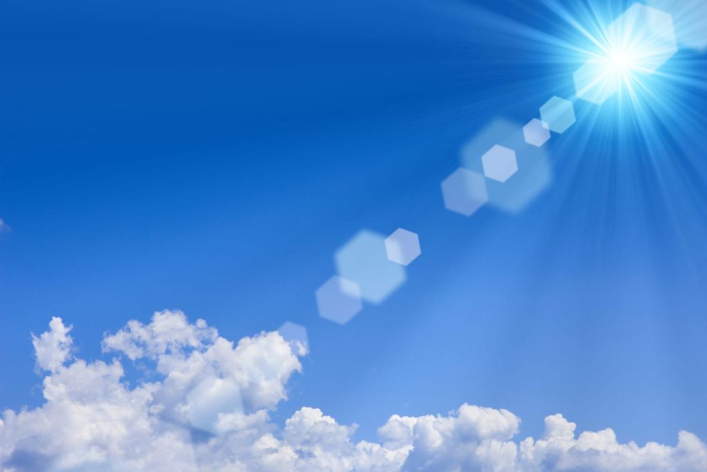 Decorative image showing pixelated spots on a ray of sunlight streaking across a blue sky to a patch of fluffy clouds.