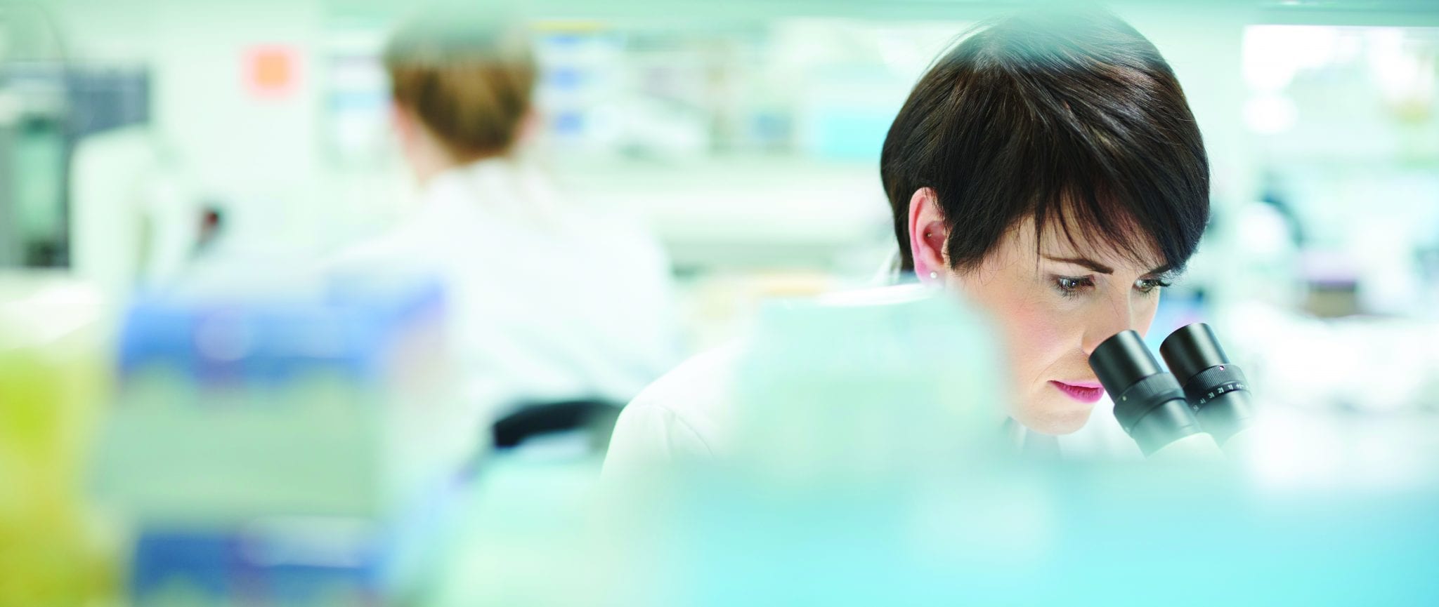 female scientist in a busy research lab