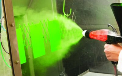 Green powder coating is sprayed onto a surface.