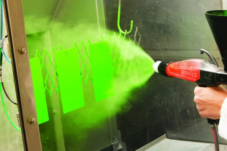 Green powder coating is sprayed onto a surface.