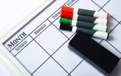Blank white calendar with dry erase markers and an eraser