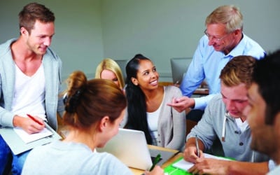Teacher helping college students in study class