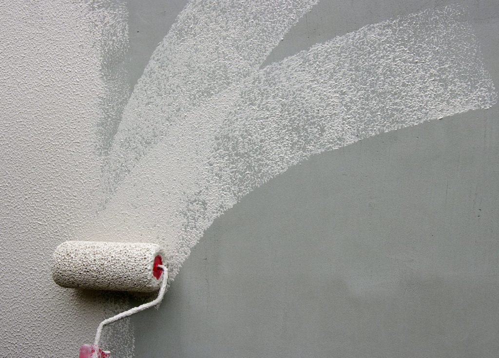 Hand painting a wall with a paint roller