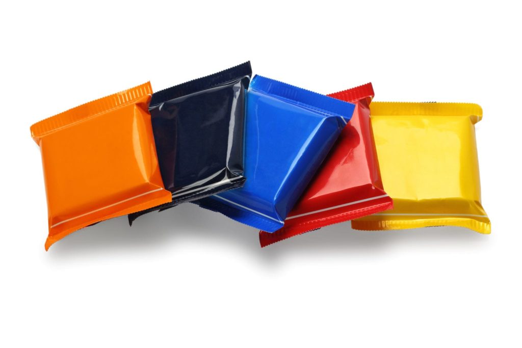 Row of Chocolate Bars In Colourful Plastic Wrappers on White Background