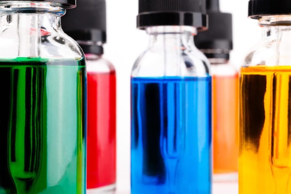 transparent glass bottles filled colored liquid with dropper. white background.