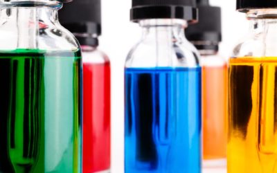 transparent glass bottles filled colored liquid with dropper. white background.