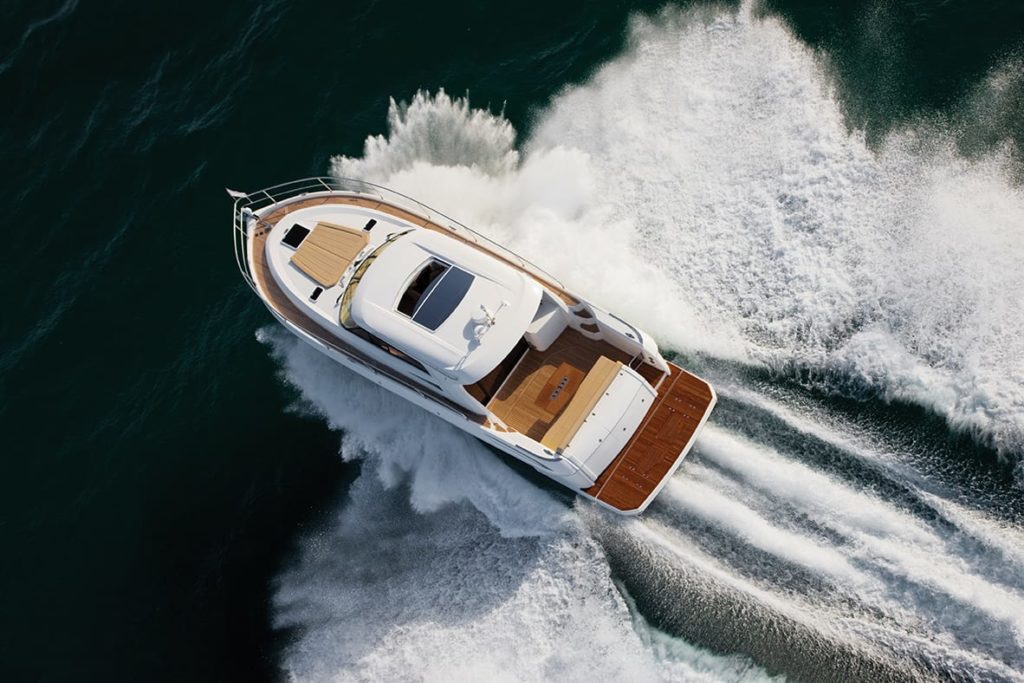 Small yacht sailing at very high speed and splashing water to all sides