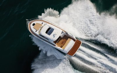 Small yacht sailing at very high speed and splashing water to all sides
