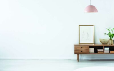 Retro pink ceiling lamp above a wooden sideboard in a modern living room interior