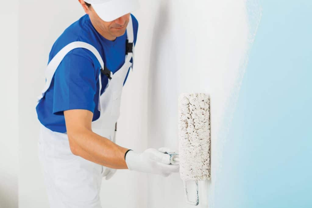 painter painting a wall with paint roller