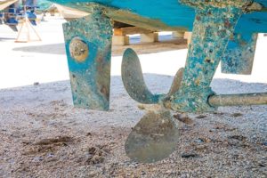 Rudder with anode, propeller and shaft of yacht in dry dock for maintenance