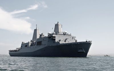 The USS Somerset (LPD-25) looms over a Naval Special Warfare boat in the San Diego Bay.