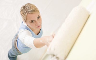 Woman painting a wall with a roller
