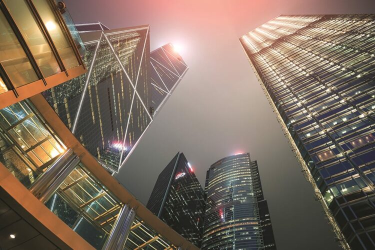 Perspective view of building in downtown hong kong city with light at night time.