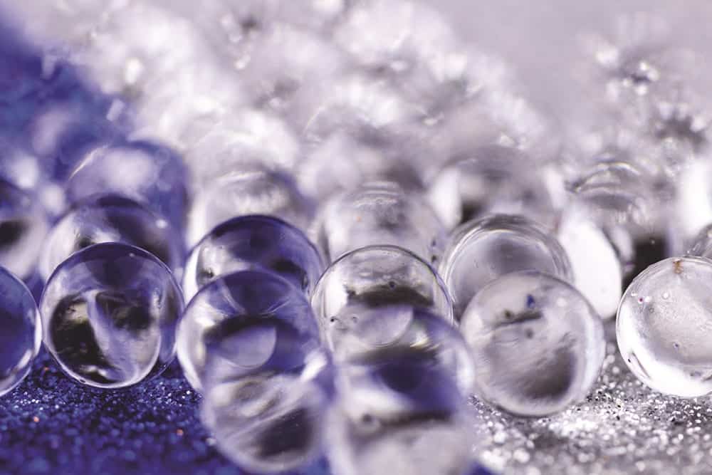 Hydrogel ball rotating on blue and silver surface. Close up macro.