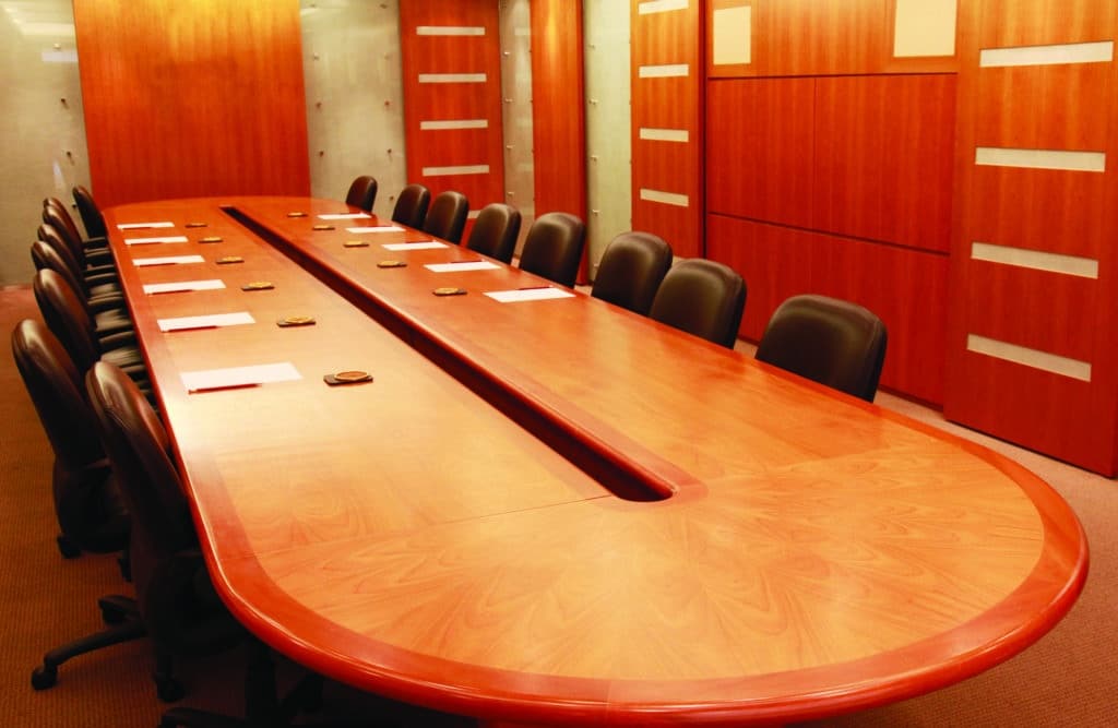 Conference room with large wooden table and leather chairs