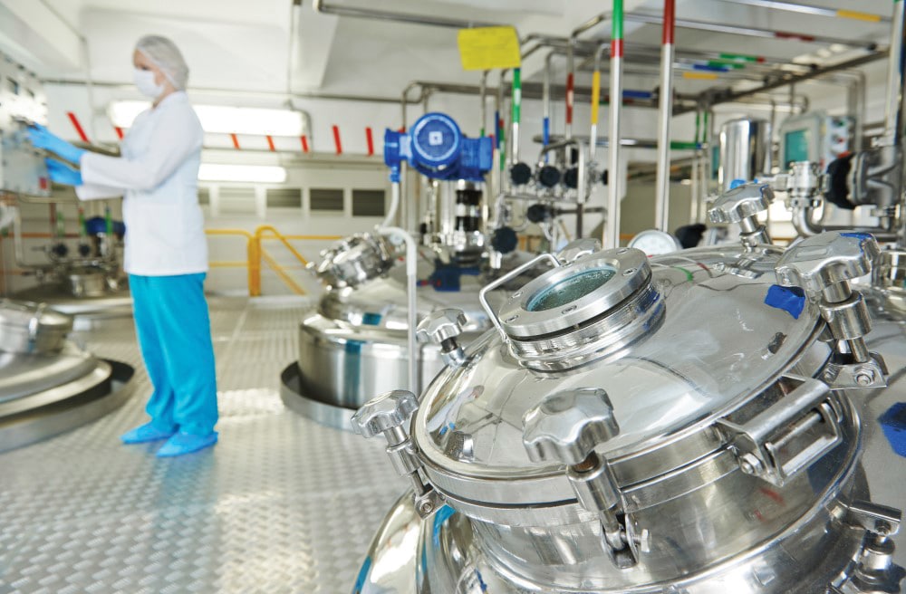 Women in labcoat checking equipment