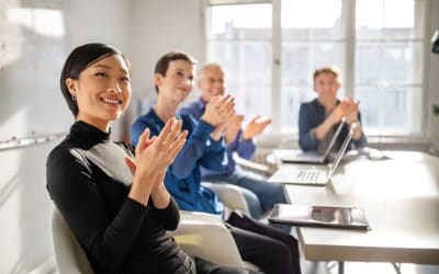 Business professionals clapping hands in a meeting