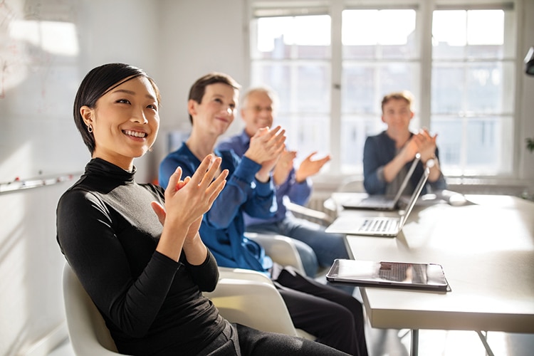 Business professionals clapping hands in a meeting