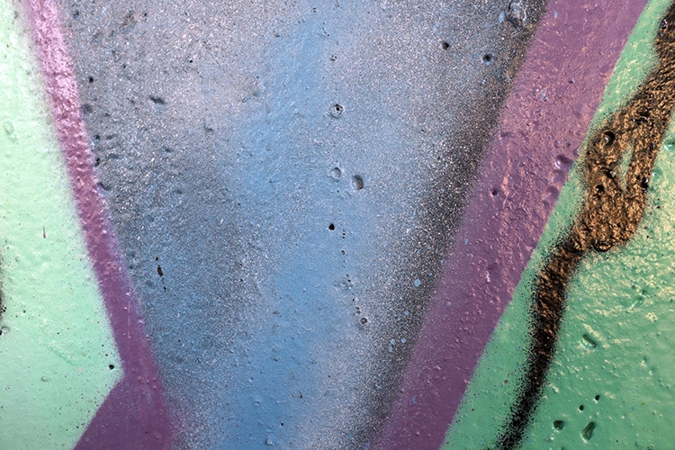 a colorful abstract image of paint on concrete