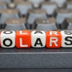 The word "scholarship" can be read on a row of dice etched with each letter.
