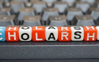 The word "scholarship" can be read on a row of dice etched with each letter.
