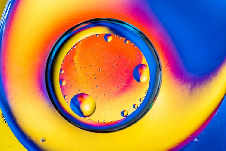 Abstract background with colorful gradient colors. Oil drops in water abstract psychedelic pattern image. Blue orange yellow colored abstract pattern