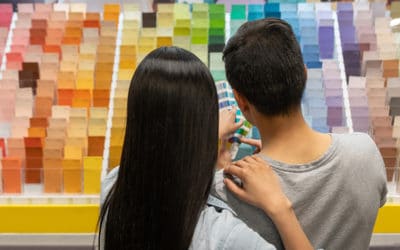 Couple at hardware store choosing a color for their house project