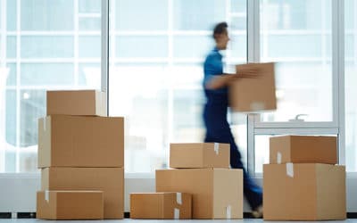 Blurred motion of contemporary worker with packed box walking to new office while delivering it to client