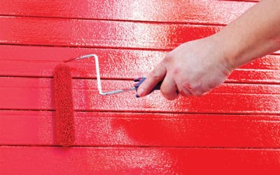 hand rolling red paint on wall