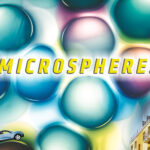 Graphic of a headline reading "Microspheres" on a background of colorful microscopic bubbles that resemble water droplets. A tiny SUV drives over the top of one of these bubbles, and a picture of the side of a building is used decoratively in the corner of the graphic.