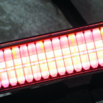 Set of yellow lights in small cylinders are arranged side by side in a row surrounded by a red glowing light.