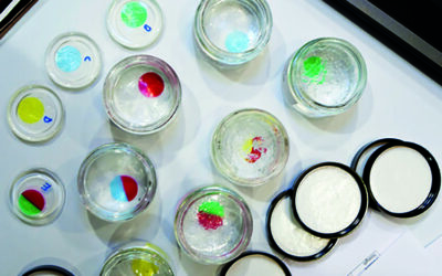 Decorative image of petri dishes with drops of colorful liquid.