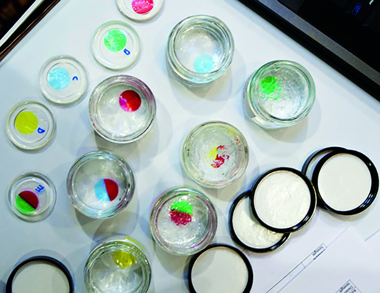 Decorative image of petri dishes with drops of colorful liquid.