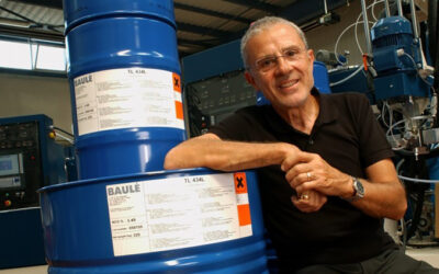 Michel Baulé, Covestro Elastomer founder, next to a blue barrel bearing his last name.